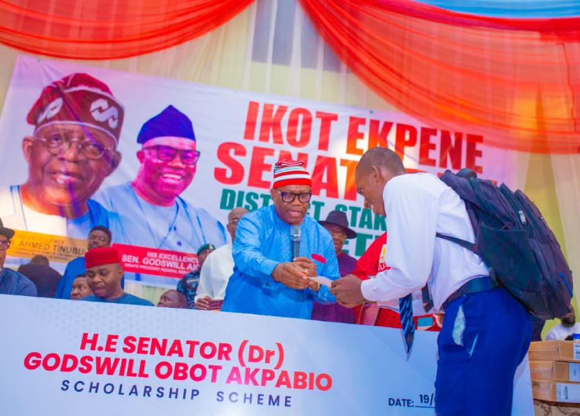 Senate President, God's will AKPABIO, handing a cheque leaf to a constituent.