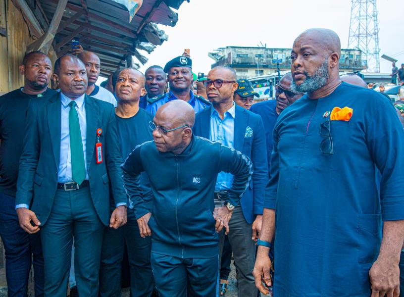 Governor Otti is keenly observing part of the burnt terminal building. Standing right is Mayor of Aba South, Chief Uche Wogu.
