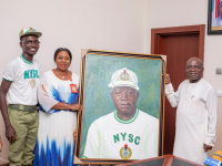 Governor Otti is presented with a portrait of himself in NYSC uniform by Mrs. Adama and the youth corps member who painted the work.